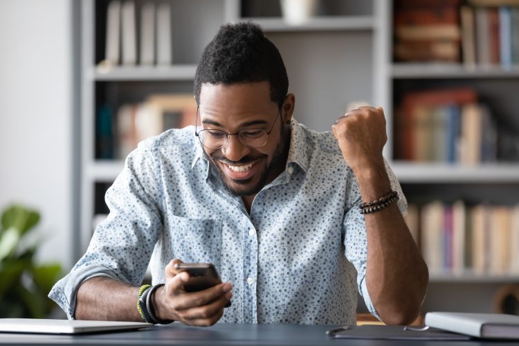 Smiling man staring at his smartphone.