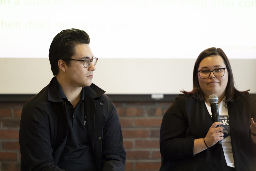 Two people in conversation, one holding a microphone